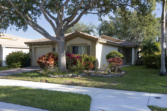 view of front facade featuring an attached garage, stucco siding, a tile roof, and a front lawn