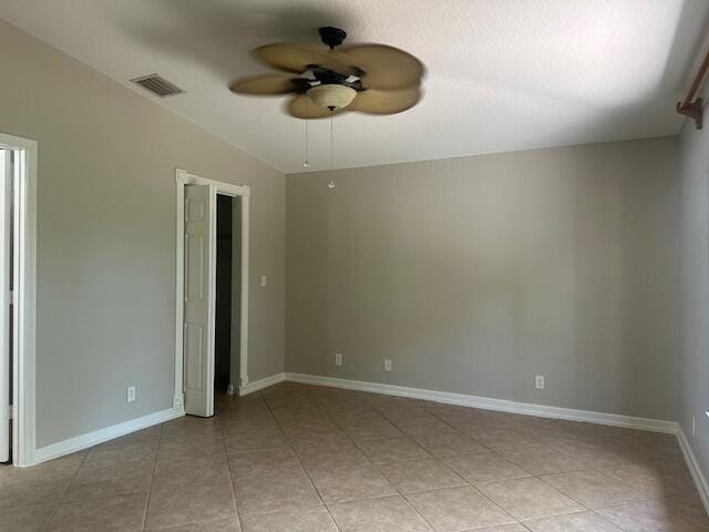 spare room featuring a ceiling fan, light tile patterned floors, and baseboards