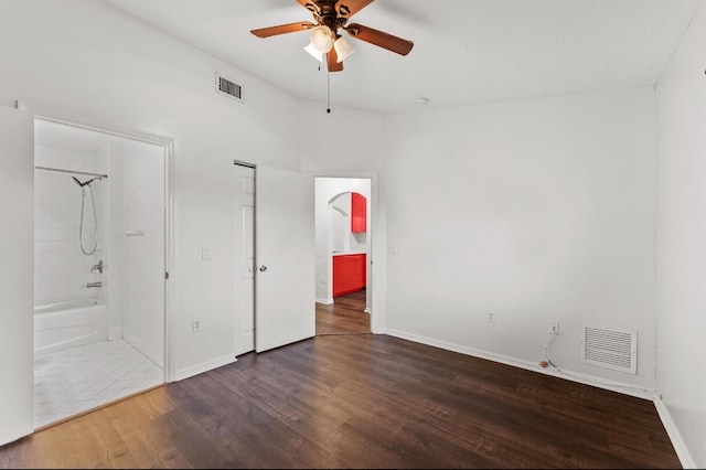 unfurnished bedroom with wood finished floors, connected bathroom, baseboards, and a ceiling fan