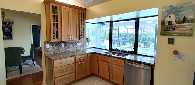 1132 SE Oriental Ave, Port Saint Lucie, FL 34952 - kitchen featuring dishwasher, a sink, healthy amount of natural light, and light stone countertops