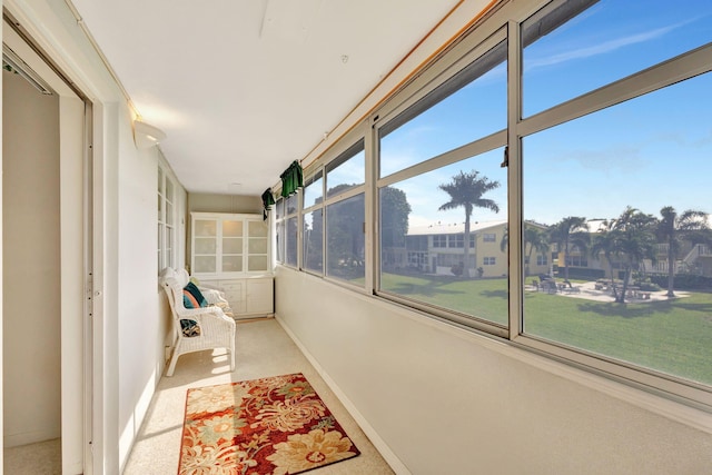 unfurnished sunroom with baseboards and carpet floors