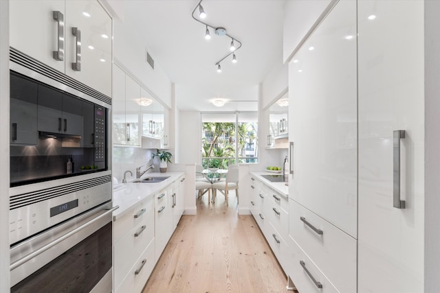 500 SE Mizner Blvd Unit A202, Boca Raton, FL 33432 - kitchen featuring modern cabinets, stainless steel oven, white cabinetry, and light wood-type flooring