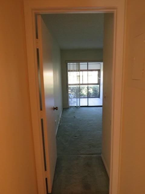 816 Sky Pine Way Unit H, Greenacres, FL 33415 - hallway featuring dark colored carpet and baseboards