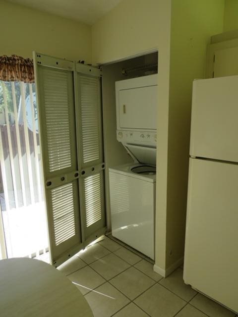 816 Sky Pine Way Unit H, Greenacres, FL 33415 - laundry room with stacked washer / drying machine and light tile patterned floors