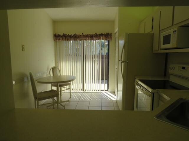 816 Sky Pine Way Unit H, Greenacres, FL 33415 - kitchen with white appliances, tile patterned floors, a sink, and light countertops