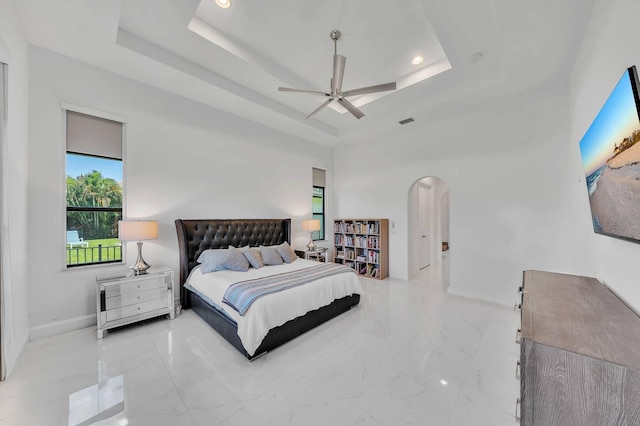9219 Grand Prix Ln, Boynton Beach, FL 33472 - bedroom with a tray ceiling, arched walkways, baseboards, recessed lighting, and marble finish flooring