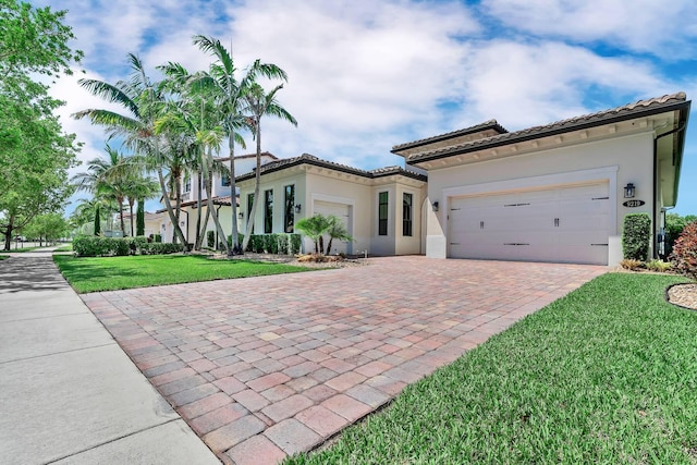 9219 Grand Prix Ln, Boynton Beach, FL 33472 - mediterranean / spanish house with decorative driveway, stucco siding, an attached garage, a front yard, and a tile roof