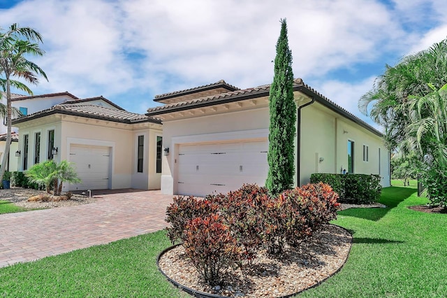 9219 Grand Prix Ln, Boynton Beach, FL 33472 - mediterranean / spanish home featuring an attached garage, stucco siding, a front yard, decorative driveway, and a tiled roof