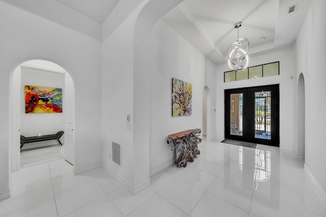 9219 Grand Prix Ln, Boynton Beach, FL 33472 - tiled entryway featuring arched walkways, a towering ceiling, baseboards, and french doors