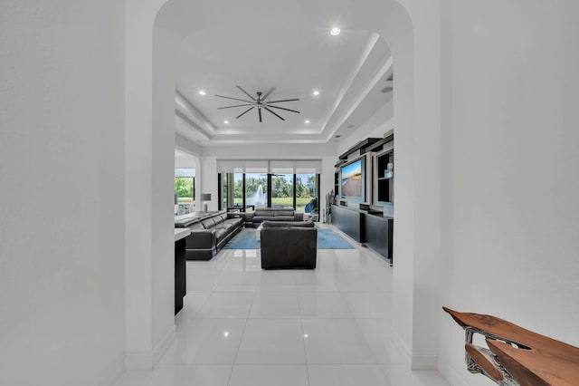 9219 Grand Prix Ln, Boynton Beach, FL 33472 - living area with arched walkways, baseboards, recessed lighting, light tile patterned floors, and a raised ceiling