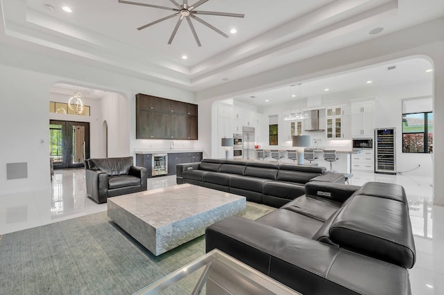 9219 Grand Prix Ln, Boynton Beach, FL 33472 - living area featuring arched walkways, wine cooler, a tray ceiling, a chandelier, and recessed lighting