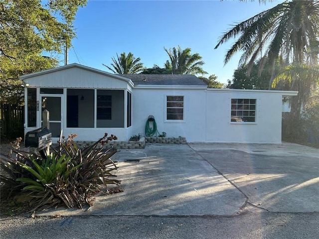 132 E Central Blvd, Lantana, FL 33462 - view of front facade featuring a sunroom, stucco siding, and driveway