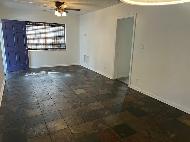 132 E Central Blvd, Lantana, FL 33462 - unfurnished room with ceiling fan, a textured ceiling, baseboards, and stone tile floors