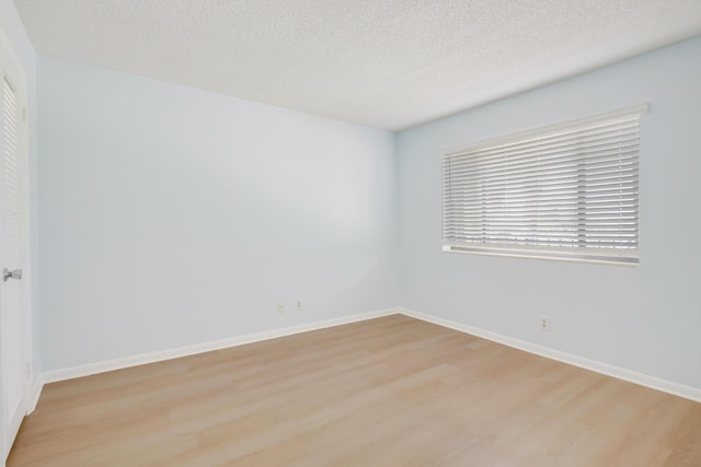 4411 Trevi Ct Unit 303, Lake Worth, FL 33467 - unfurnished room featuring light wood-style floors, a textured ceiling, and baseboards