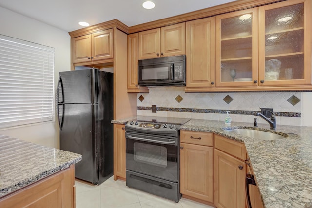 4411 Trevi Ct Unit 303, Lake Worth, FL 33467 - kitchen with black appliances, a sink, light stone countertops, tasteful backsplash, and light tile patterned floors