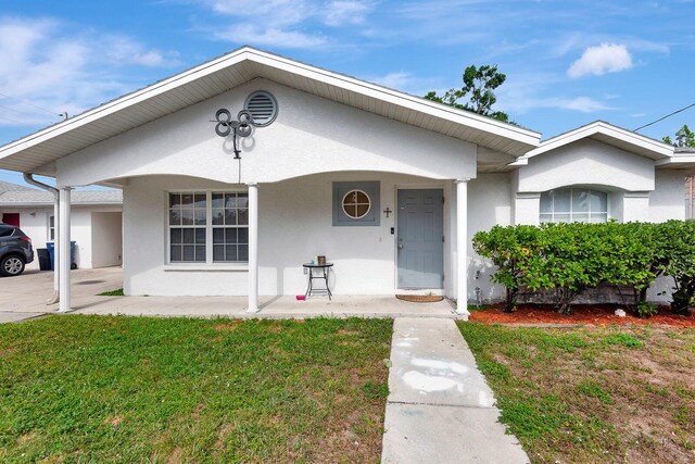 6528/6530 12th St W, Bradenton, FL 34207 - view of front facade featuring stucco siding, a front lawn, and a porch