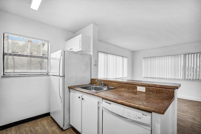 1618 Meadows Cir W, Boynton Beach, FL 33436 - kitchen featuring white appliances, a peninsula, a sink, dark countertops, and baseboards