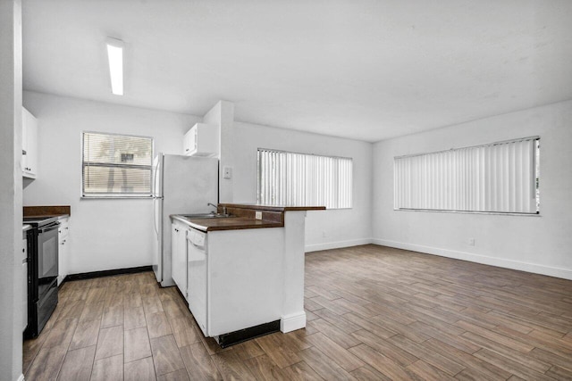 1618 Meadows Cir W, Boynton Beach, FL 33436 - kitchen with electric range, dark countertops, white cabinetry, and dark wood finished floors