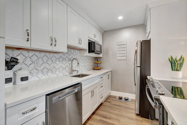 1044 Cambridge C Unit 1044, Deerfield Beach, FL 33442 - kitchen featuring stainless steel appliances, a sink, baseboards, tasteful backsplash, and white cabinetry