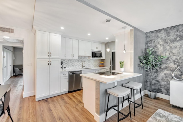 1044 Cambridge C Unit 1044, Deerfield Beach, FL 33442 - kitchen with stainless steel appliances, a breakfast bar, white cabinetry, baseboards, and a sink