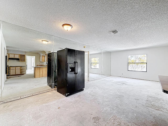5701 Autumn Ridge Rd, Lake Worth, FL 33463 - kitchen with black refrigerator with ice dispenser, open floor plan, freestanding refrigerator, and a textured ceiling