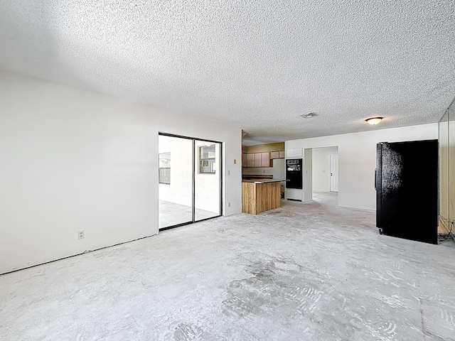 5701 Autumn Ridge Rd, Lake Worth, FL 33463 - unfurnished living room with a textured ceiling and unfinished concrete flooring