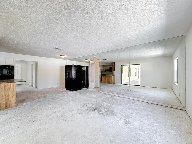 5701 Autumn Ridge Rd, Lake Worth, FL 33463 - unfurnished living room with a textured ceiling and concrete floors