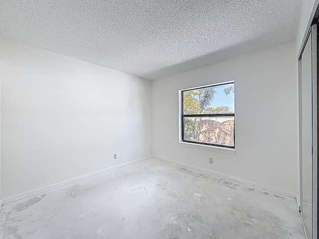 5701 Autumn Ridge Rd, Lake Worth, FL 33463 - empty room featuring a textured ceiling, unfinished concrete floors, and baseboards