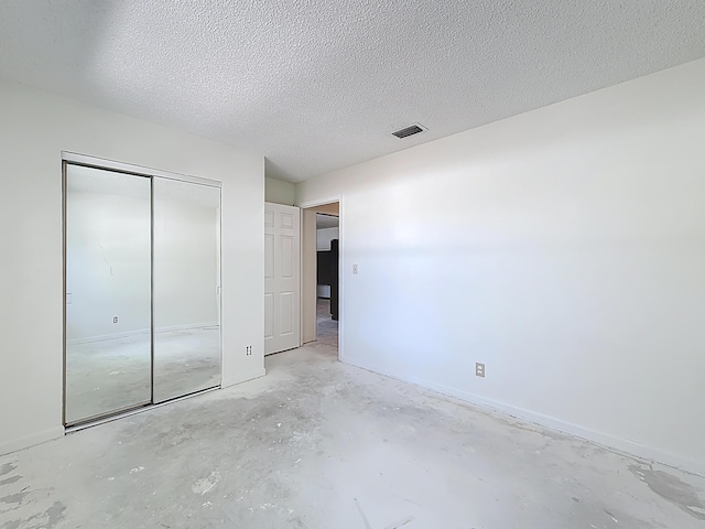 5701 Autumn Ridge Rd, Lake Worth, FL 33463 - unfurnished bedroom featuring unfinished concrete floors, a closet, a textured ceiling, and baseboards