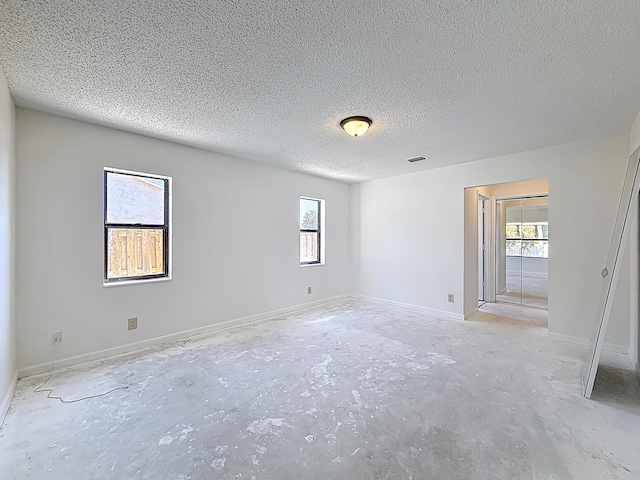 5701 Autumn Ridge Rd, Lake Worth, FL 33463 - empty room featuring unfinished concrete floors, a textured ceiling, and baseboards