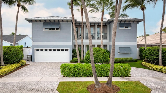 311 SE 11th St, Pompano Beach, FL 33060 - view of front of house featuring a standing seam roof, decorative driveway, a garage, metal roof, and a balcony