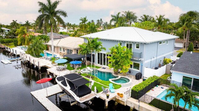 311 SE 11th St, Pompano Beach, FL 33060 - back of house featuring boat lift, a fenced backyard, a water view, and a patio