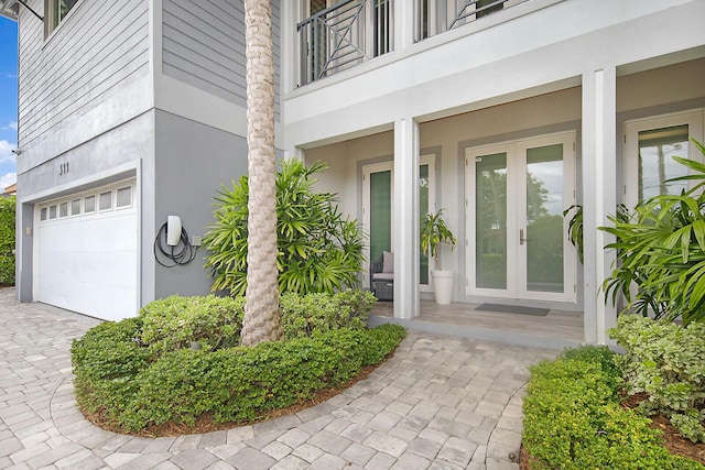 311 SE 11th St, Pompano Beach, FL 33060 - doorway to property with a garage, french doors, a balcony, stucco siding, and driveway