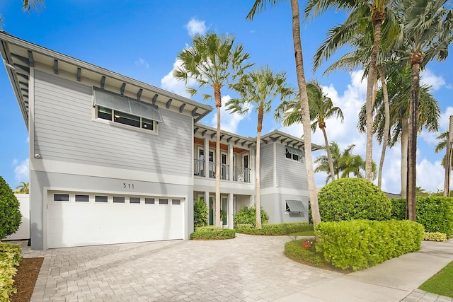 311 SE 11th St, Pompano Beach, FL 33060 - view of front facade with a balcony, a garage, decorative driveway, and stucco siding