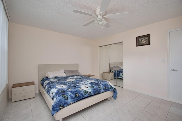 2301 Lucaya Ln Unit M3, Coconut Creek, FL 33066 - bedroom with a closet, light tile patterned floors, a textured ceiling, ceiling fan, and baseboards