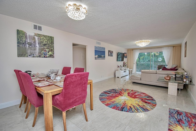 2301 Lucaya Ln Unit M3, Coconut Creek, FL 33066 - dining space with a textured ceiling, baseboards, and a chandelier
