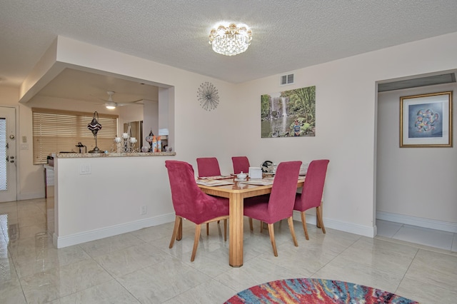 2301 Lucaya Ln Unit M3, Coconut Creek, FL 33066 - dining room with a textured ceiling, a chandelier, ceiling fan, and baseboards