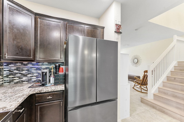 4080 Devenshire Ct, Coconut Creek, FL 33073 - kitchen with freestanding refrigerator, dark brown cabinets, tasteful backsplash, light tile patterned floors, and light stone counters