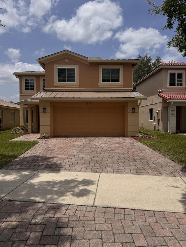 view of front of property featuring an attached garage, a standing seam roof, decorative driveway, and metal roof