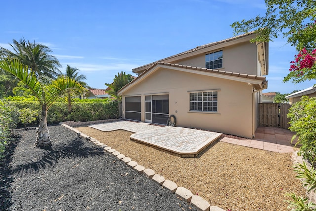 148 Cypress Cv, Jupiter, FL 33458 - rear view of house featuring a patio, stucco siding, fence, and a tile roof