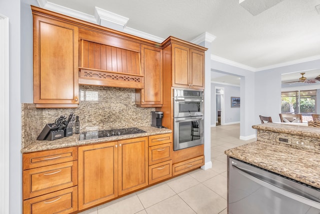 148 Cypress Cv, Jupiter, FL 33458 - kitchen with stainless steel appliances, light tile patterned floors, backsplash, brown cabinets, and ornamental molding