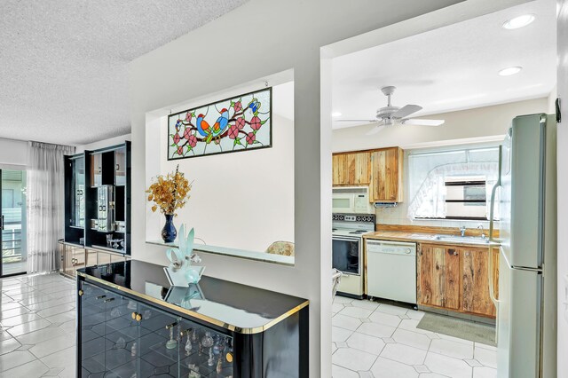 128 Capri C, Delray Beach, FL 33484 - kitchen with white appliances, a sink, a ceiling fan, a textured ceiling, and recessed lighting