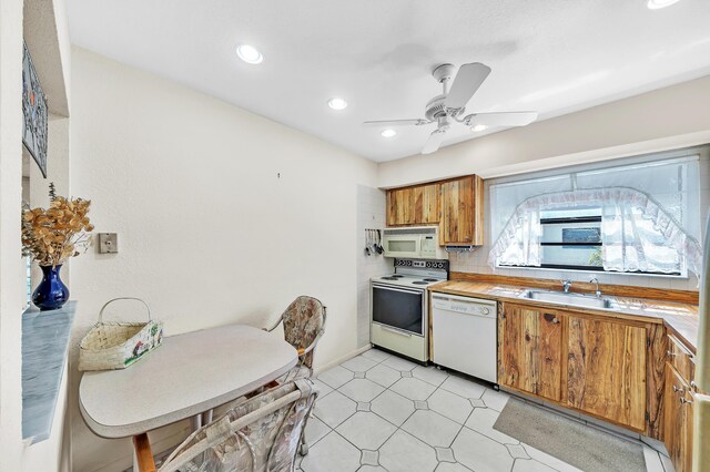 128 Capri C, Delray Beach, FL 33484 - kitchen with white appliances, a sink, brown cabinetry, light countertops, and a ceiling fan