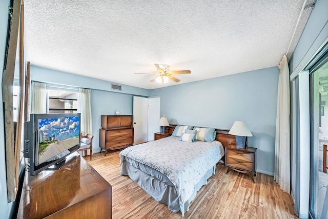 128 Capri C, Delray Beach, FL 33484 - bedroom featuring light wood-type flooring, a textured ceiling, a ceiling fan, and baseboards