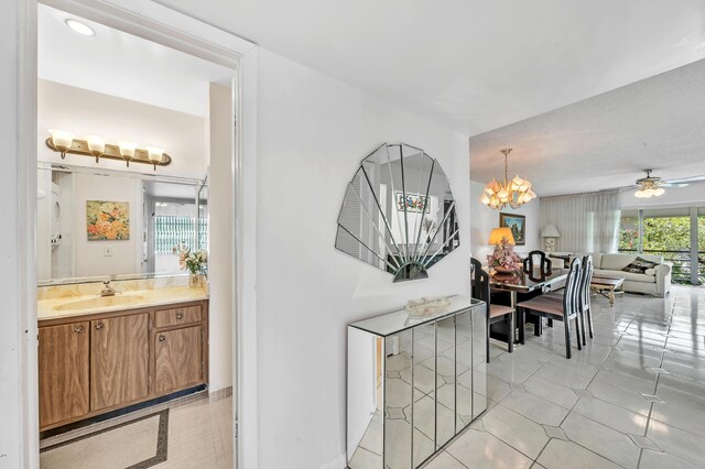 128 Capri C, Delray Beach, FL 33484 - hall with a sink, light tile patterned floors, and a chandelier