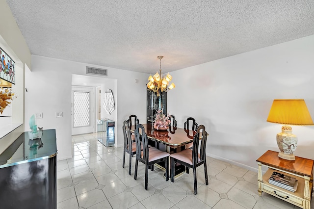 128 Capri C, Delray Beach, FL 33484 - dining room featuring a chandelier, a textured ceiling, and baseboards