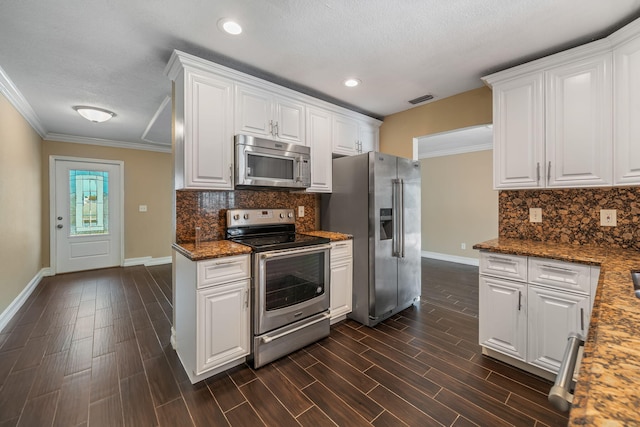 318 Gale Pl, West Palm Beach, FL 33409 - kitchen featuring stainless steel appliances, baseboards, crown molding, white cabinets, and backsplash