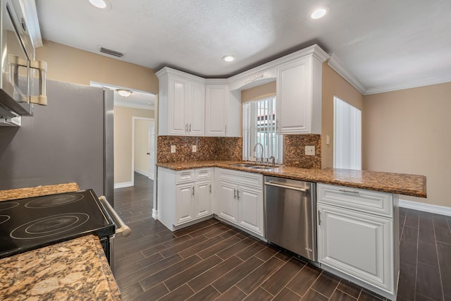 318 Gale Pl, West Palm Beach, FL 33409 - kitchen featuring appliances with stainless steel finishes, a sink, crown molding, white cabinets, and a peninsula