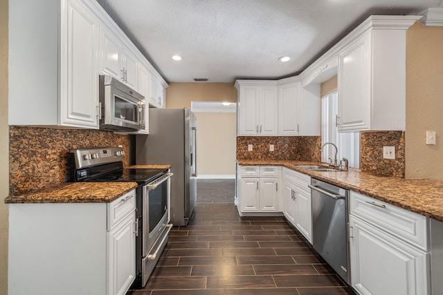 318 Gale Pl, West Palm Beach, FL 33409 - kitchen with stainless steel appliances, a sink, recessed lighting, white cabinetry, and wood finish floors
