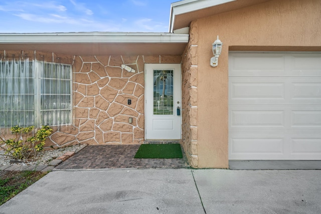 318 Gale Pl, West Palm Beach, FL 33409 - property entrance featuring an attached garage, stone siding, and stucco siding